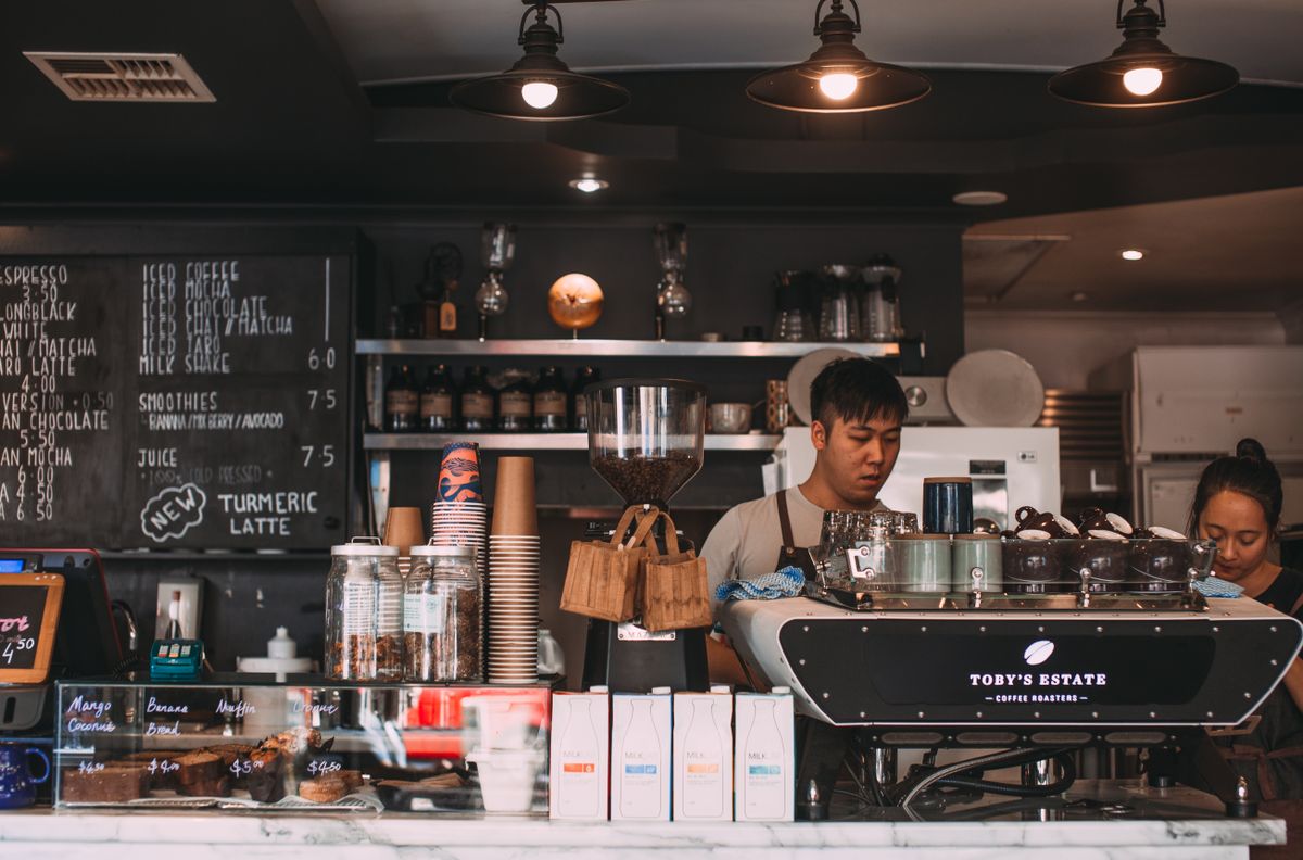 Interiorul primitor al unei cafenele cu mese și zonă de servire, pregătit pentru clienți