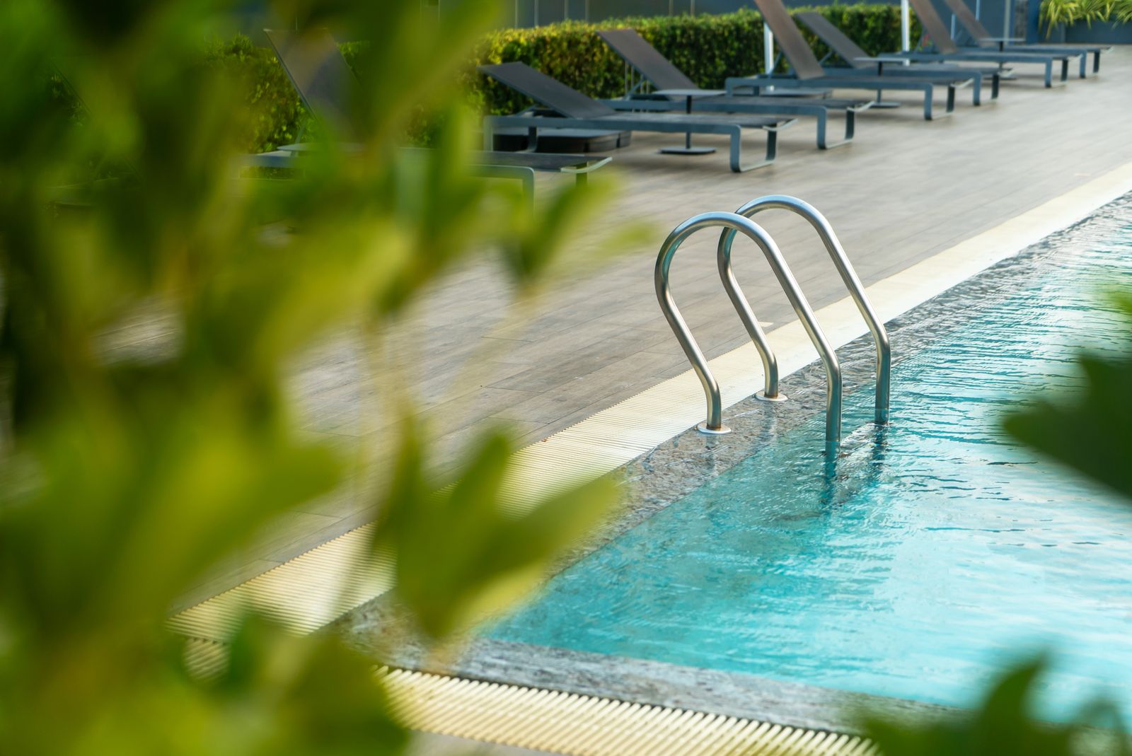 Poolside at a hotel with sun loungers and clear water